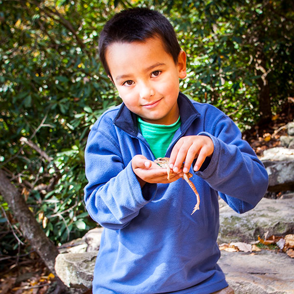 Boy playing with a frog.