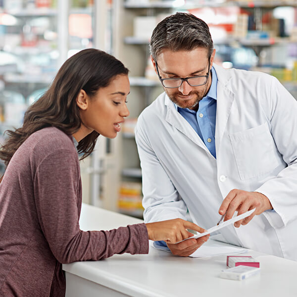 Mujer hablando con un farmacéutico 