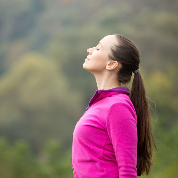 Mujer en la naturaleza controlando el estrés