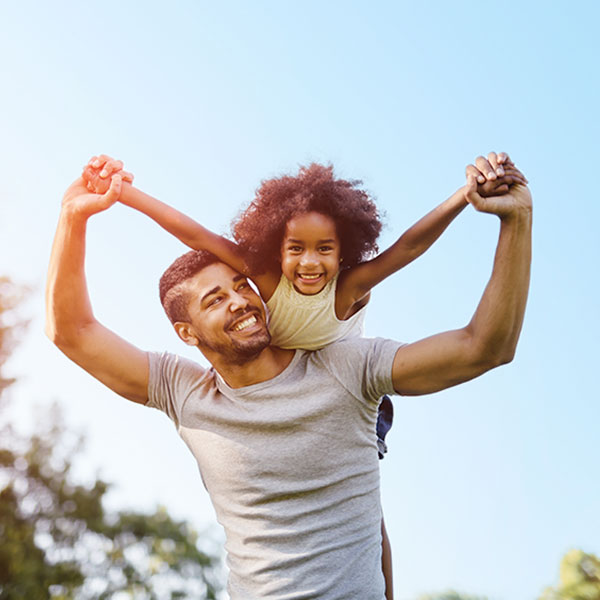 Smiling Father and Daughter by a Tree