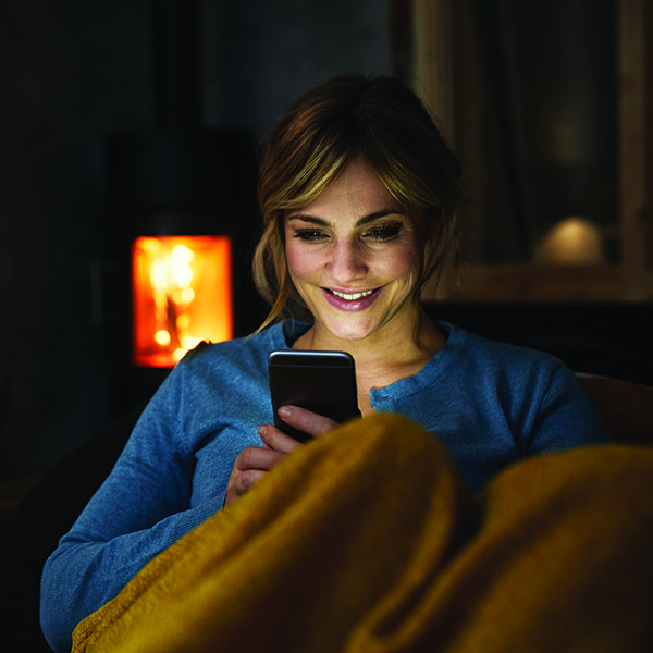 Mujer usando un teléfono en la sala de estar